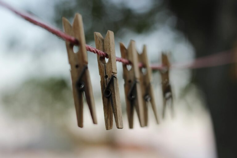 Wooden clothing pegs hanging on the washing line encouraging you to find joy in simplicity